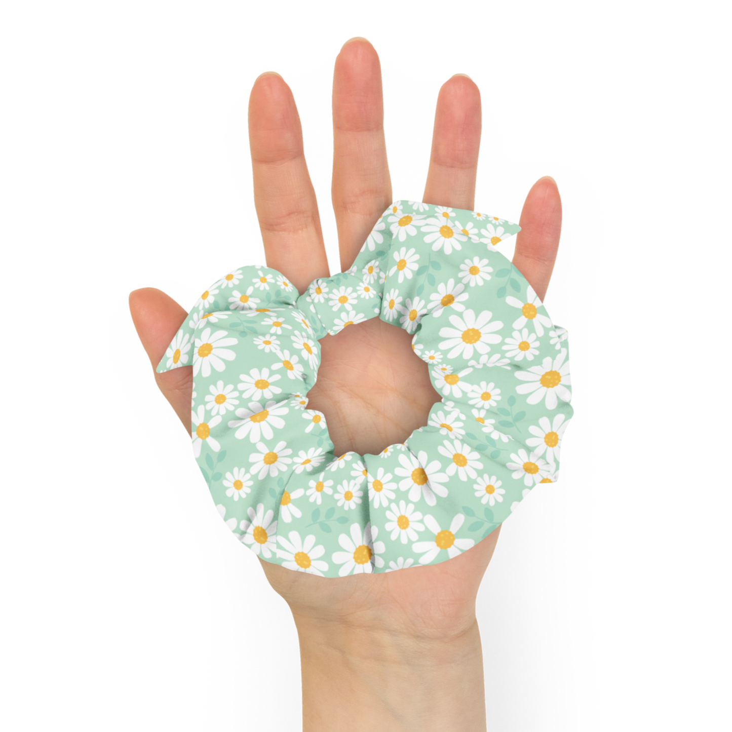 Hand holding a floral scrunchie against a white background