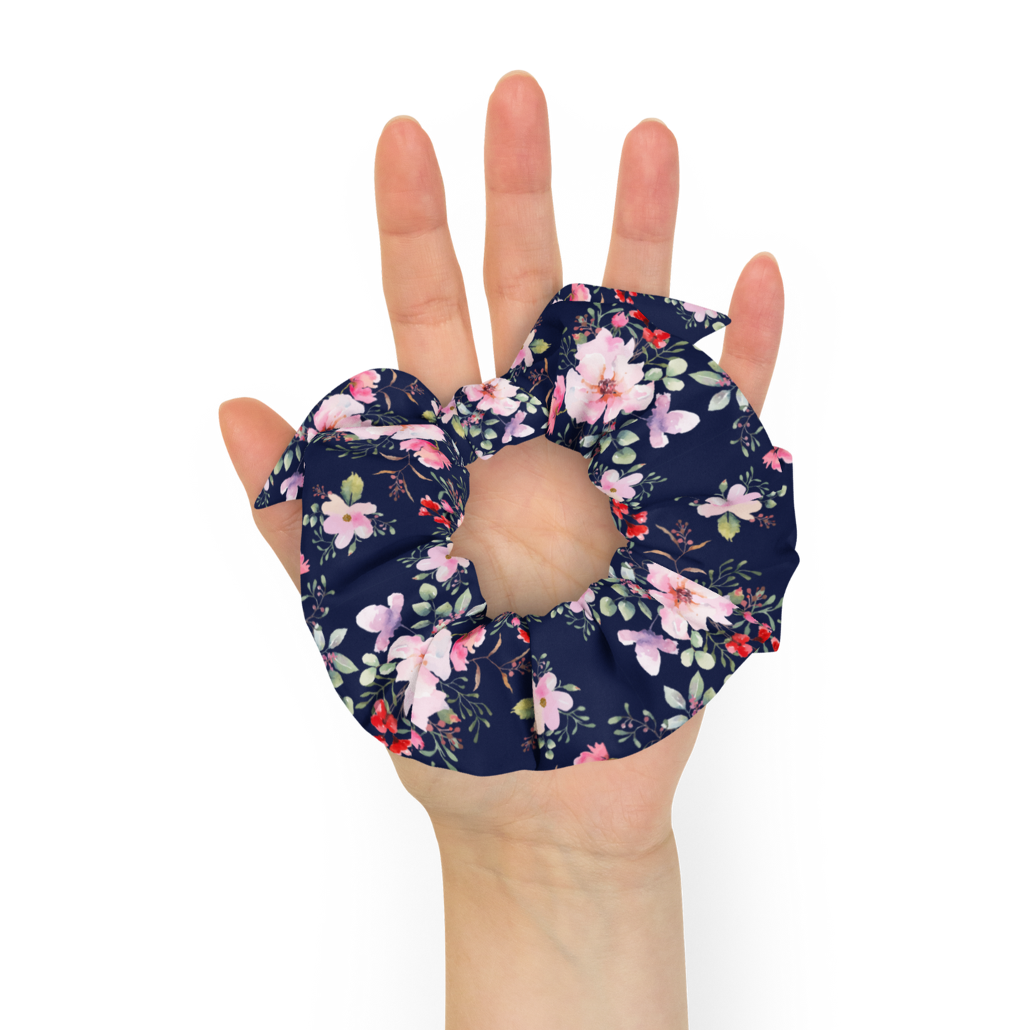 Hand holding a floral scrunchie against a white background