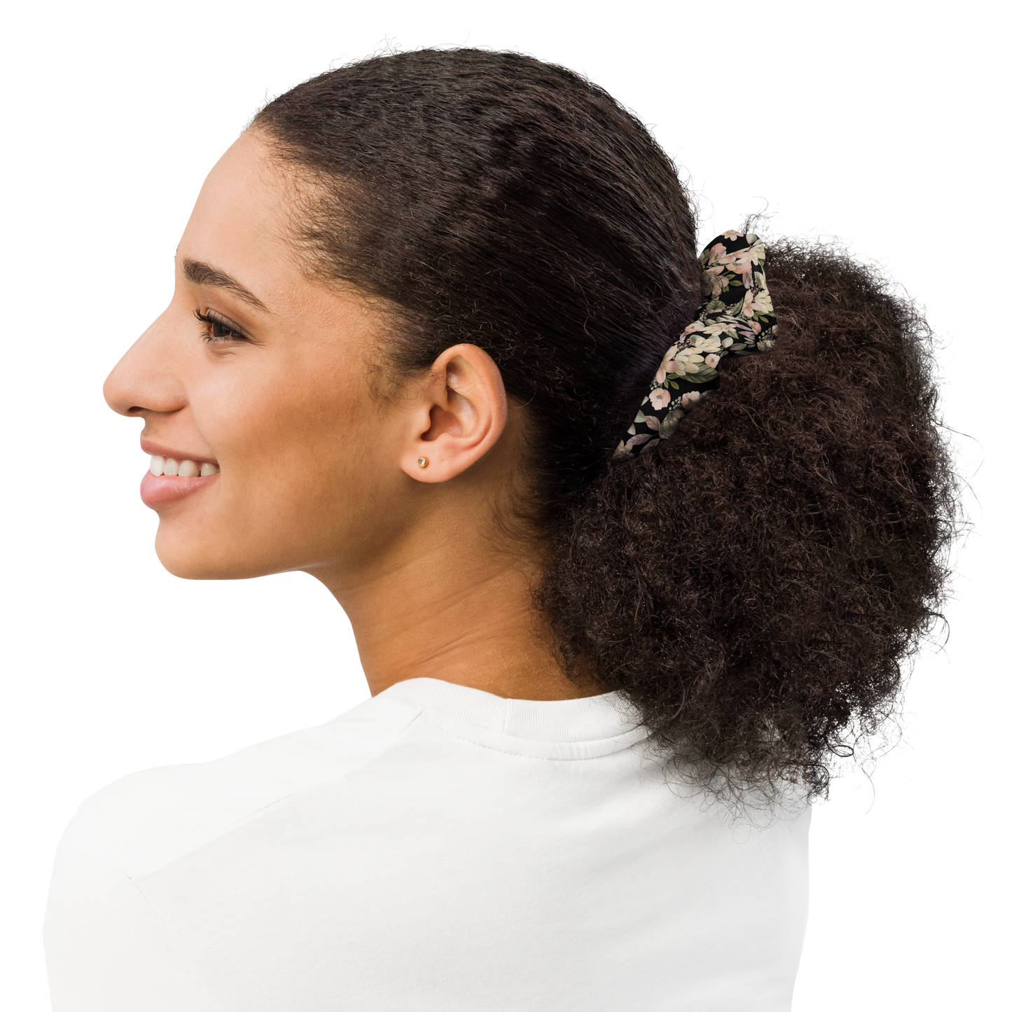 Woman with a floral hair tie in her ponytail on a white background