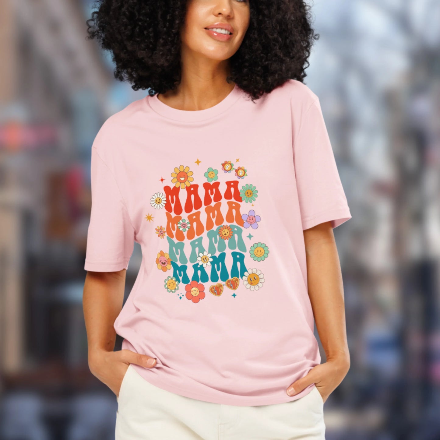 Woman wearing a pink t-shirt with 'MAMA' text and floral designs.