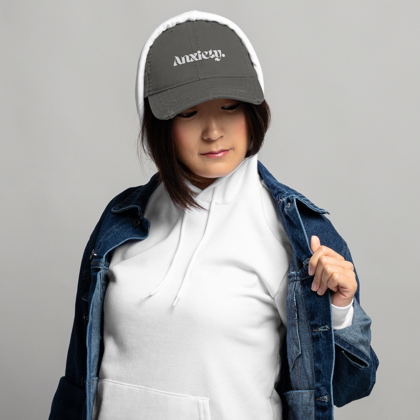 Person wearing a cap with 'Anxiety' text on a gray background