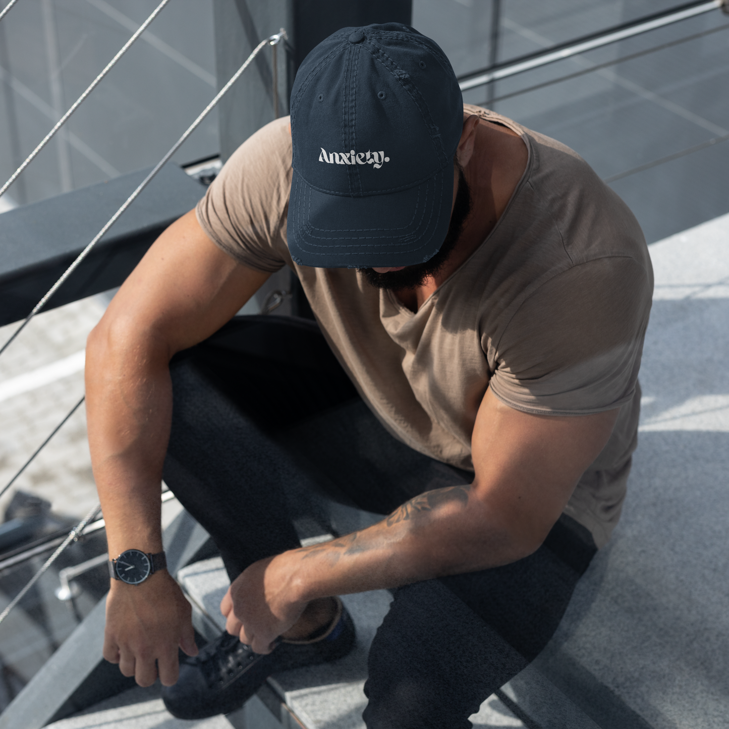 Man wearing a cap and sitting on a staircase