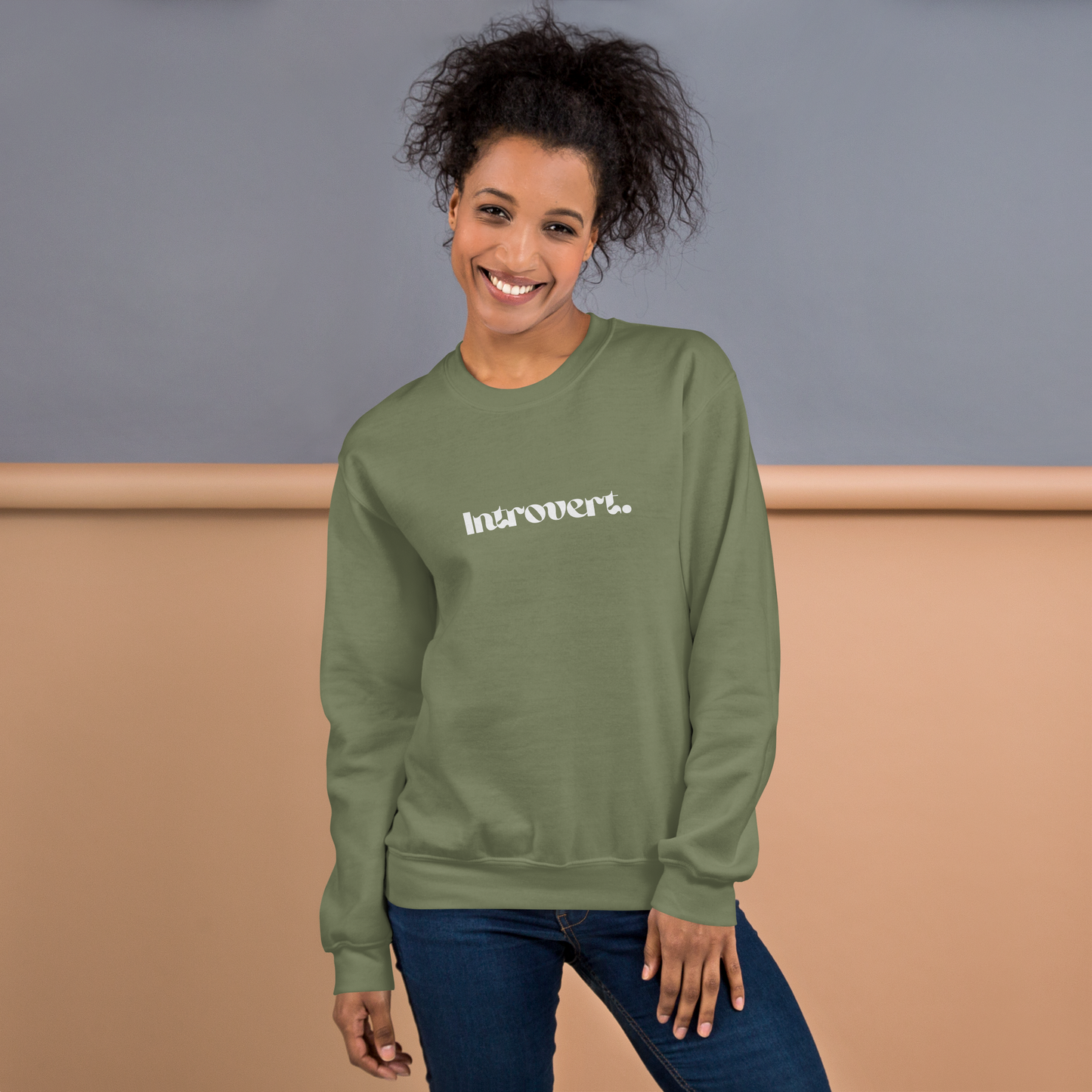 Person wearing a military green sweatshirt with 'Introvert' text against a plain background