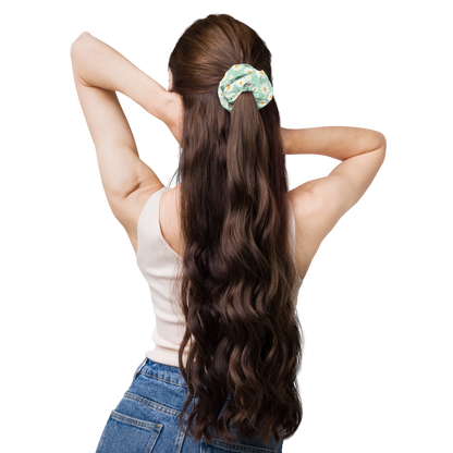 Woman with long wavy hair wearing a scrunchie on a white background