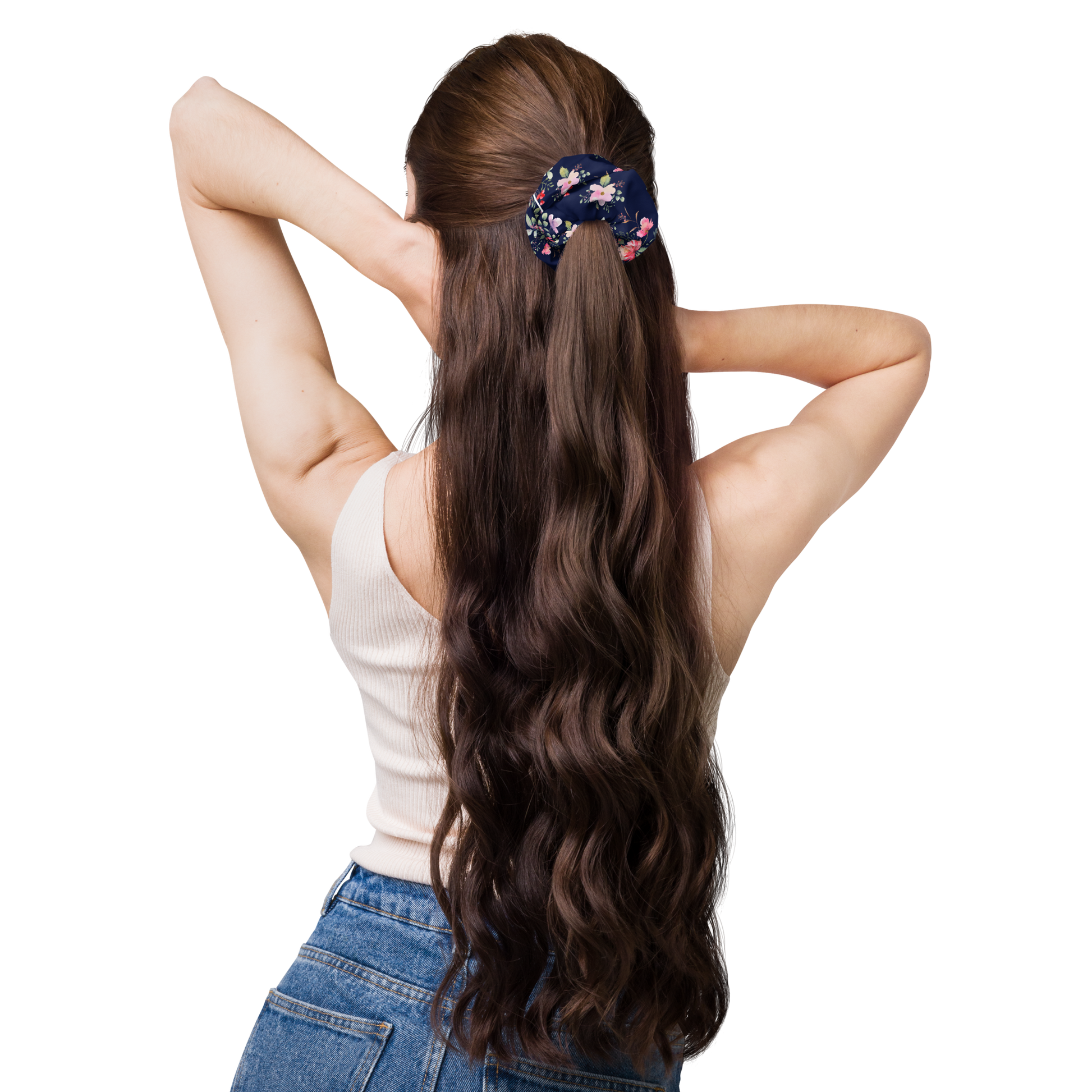 Woman with long wavy hair wearing a floral hair tie on a white background