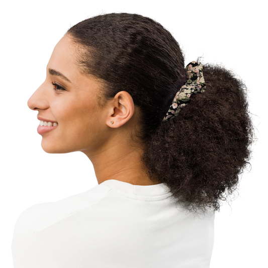 Woman with a floral hair tie in her ponytail on a white background