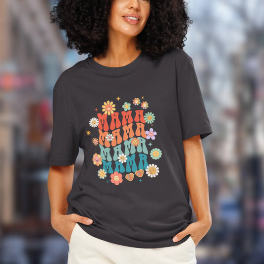Woman wearing a grey t-shirt with colorful 'MAMA' design in an urban setting