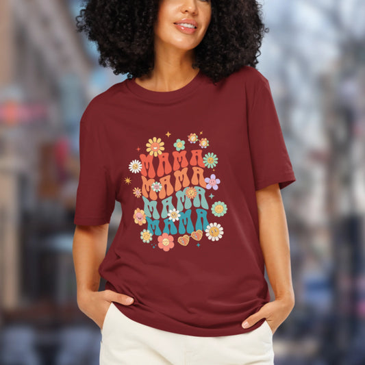 Woman wearing a maroon t-shirt with colorful 'Mama' text and floral designs.