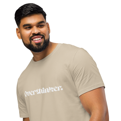 Man wearing a beige t-shirt with 'overthinker' text on a white background