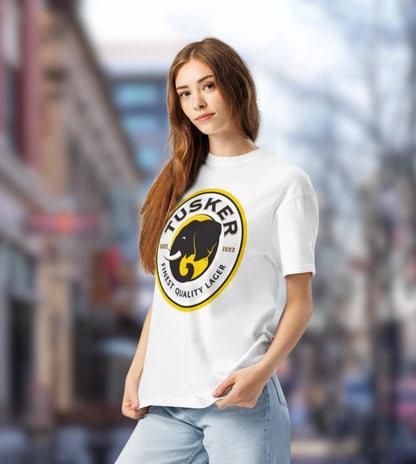 Woman wearing a white t-shirt with a yellow and black logo in an urban setting